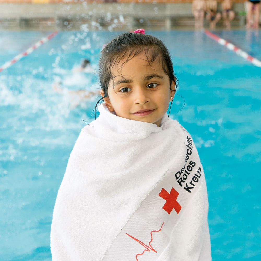 Ein kleines Mädchen sitzt in ein Handtuch gewickelt am Beckenrand im Schwimmbad, ein Motiv auf einer von der Healthcare Werbeagentur mcs gestalteten Website