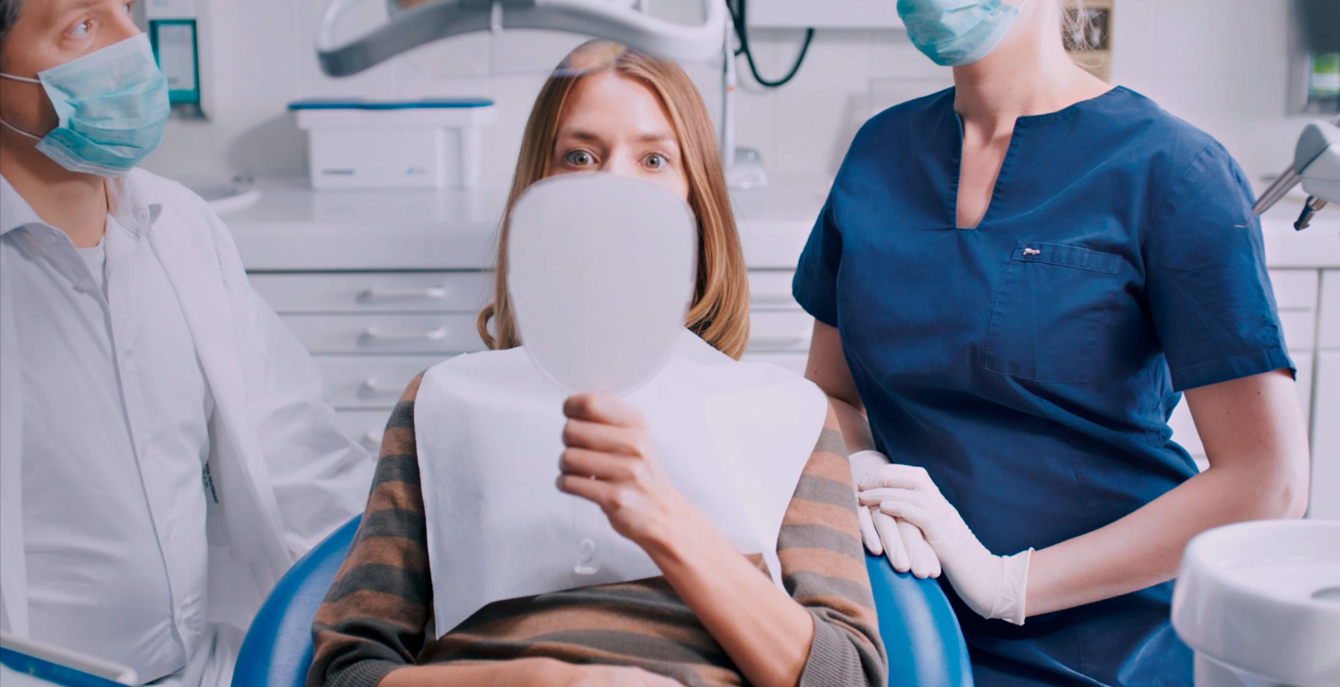 Kampagnenmotiv einer Social-Media-Kampagne der Healthcare Werbeagentur mcs mit einer Patientin beim Zahnarzt, die erstaunt in einen Handspiegel schaut
